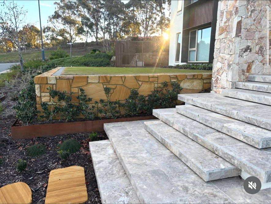 Sandstone garden wall and travertine steps at sunset in Casey